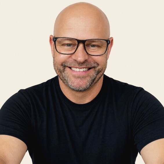 Joe Combrink smiling, wearing glasses and a black T-shirt